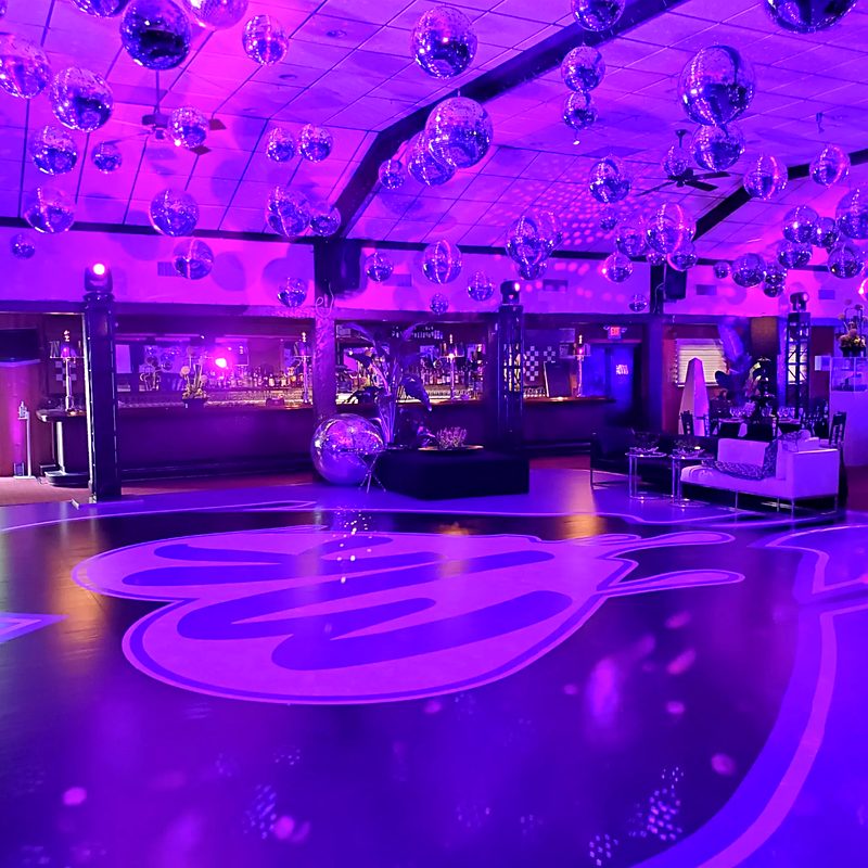 Dance floor with disco ball ceiling installation and purple production lighting