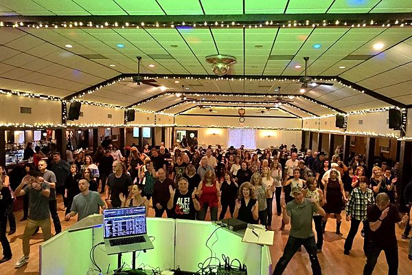 Full dance floor seen from the DJ booth with 150+ guests