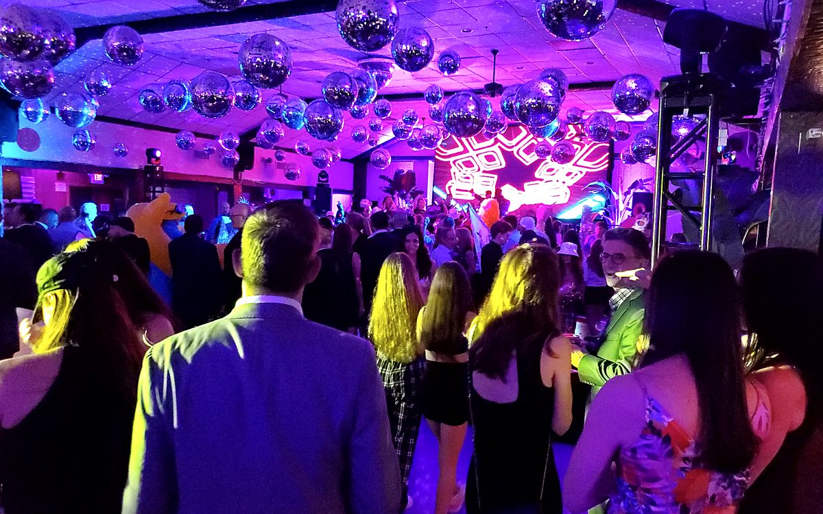 Packed dance floor with LED screen and party lighting